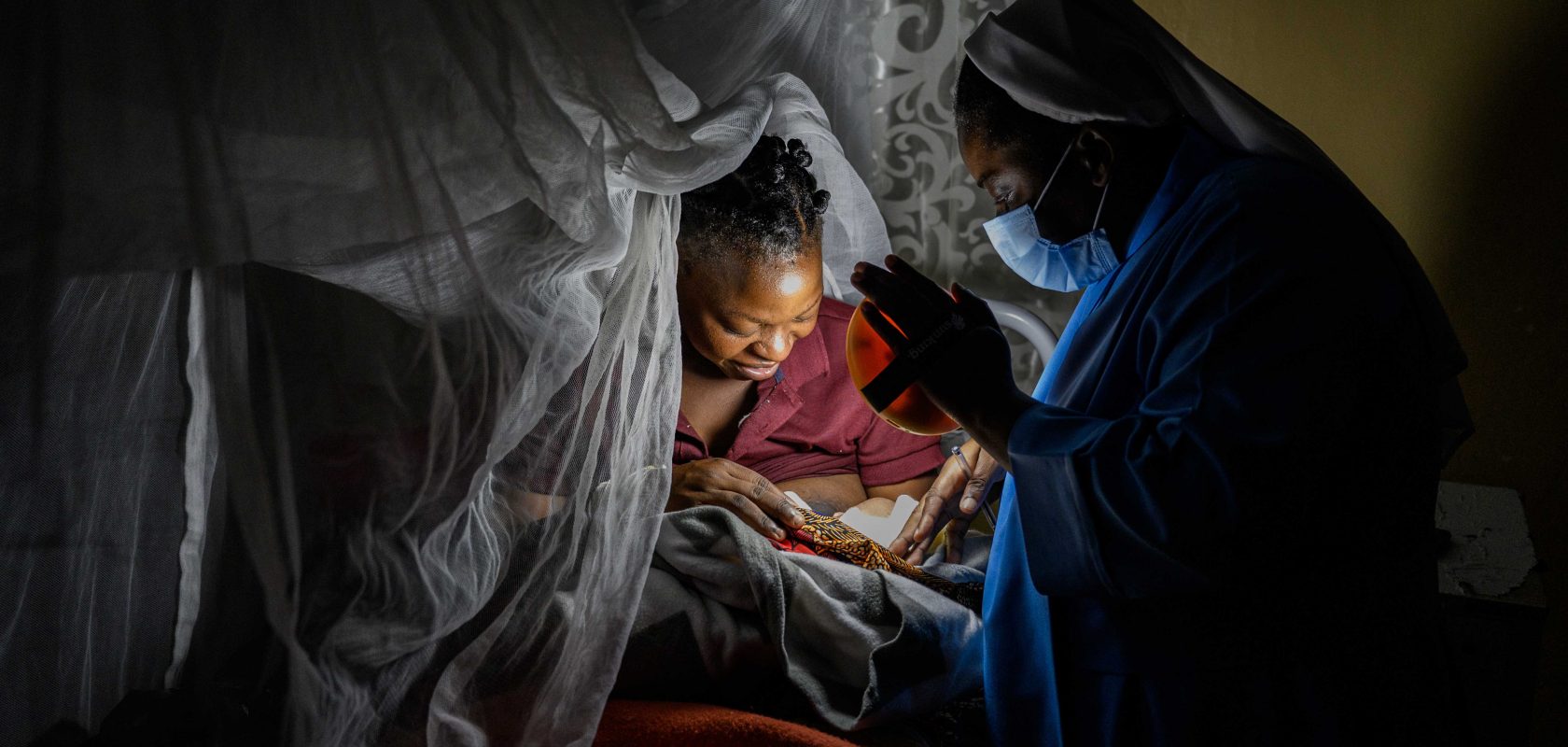 Sister Grace welcomes a newborn into the world with her solar light.