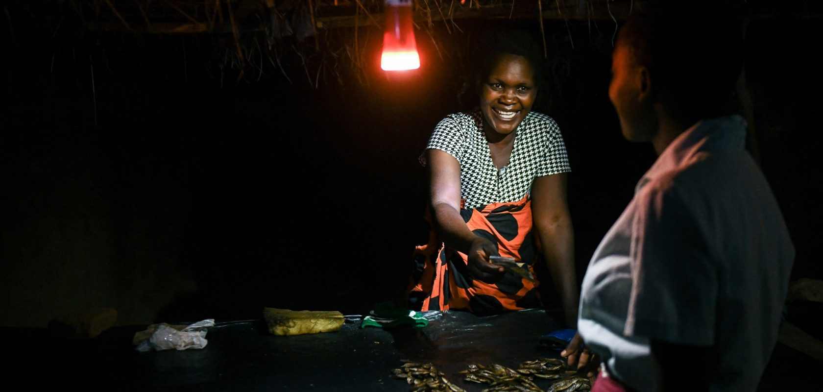 Margaret John in Malawi selling fish after dark.