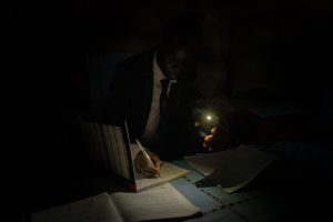 William Banda preparing by cell phone torch.