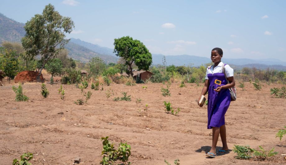 Rhoda walks to school with her solar light in hand.