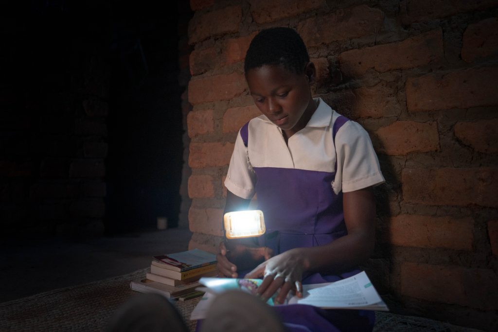 A girl reads by solar light.
