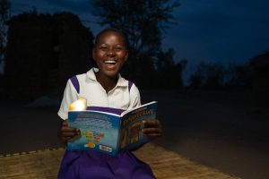 Fabriola uses her solar light to read at night