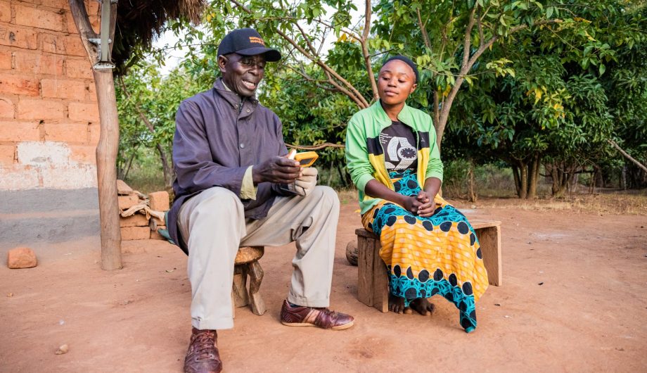 Penny Mupeta demonstrates a solar light to his customer