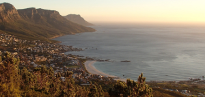 The coast line of Cape Town in South Africa, as the sun sets over the mountains.