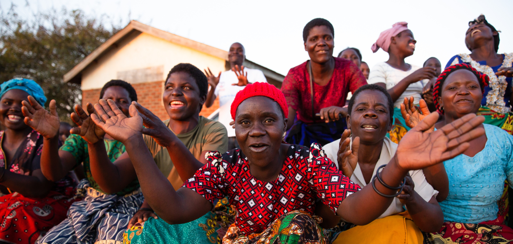 Women from the Chilima Mgwilizano Mayi Walas group in Malawi are dancing and celebrating together.