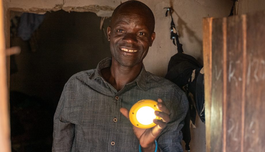 A man holds a shining solar light in his hand.