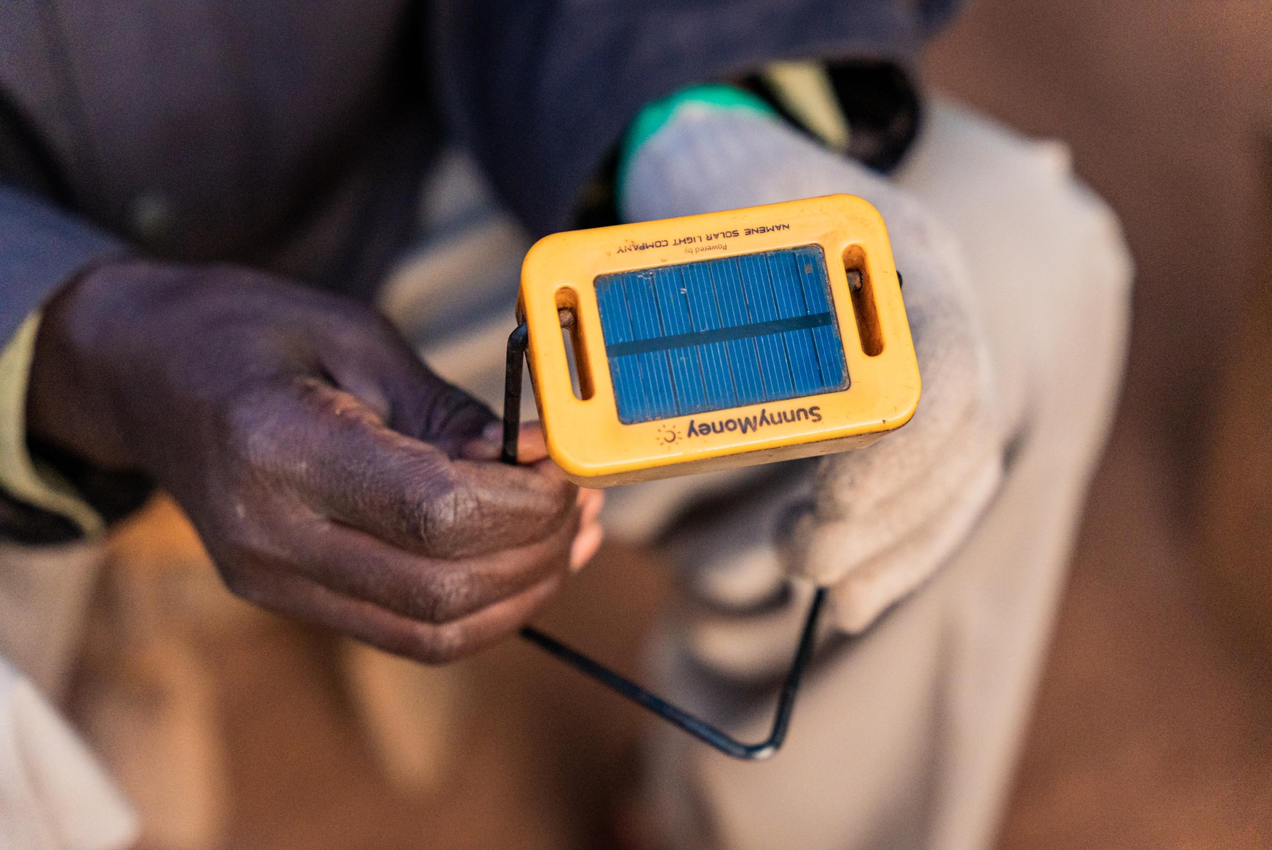 Close-up on hands holding a small solar light.