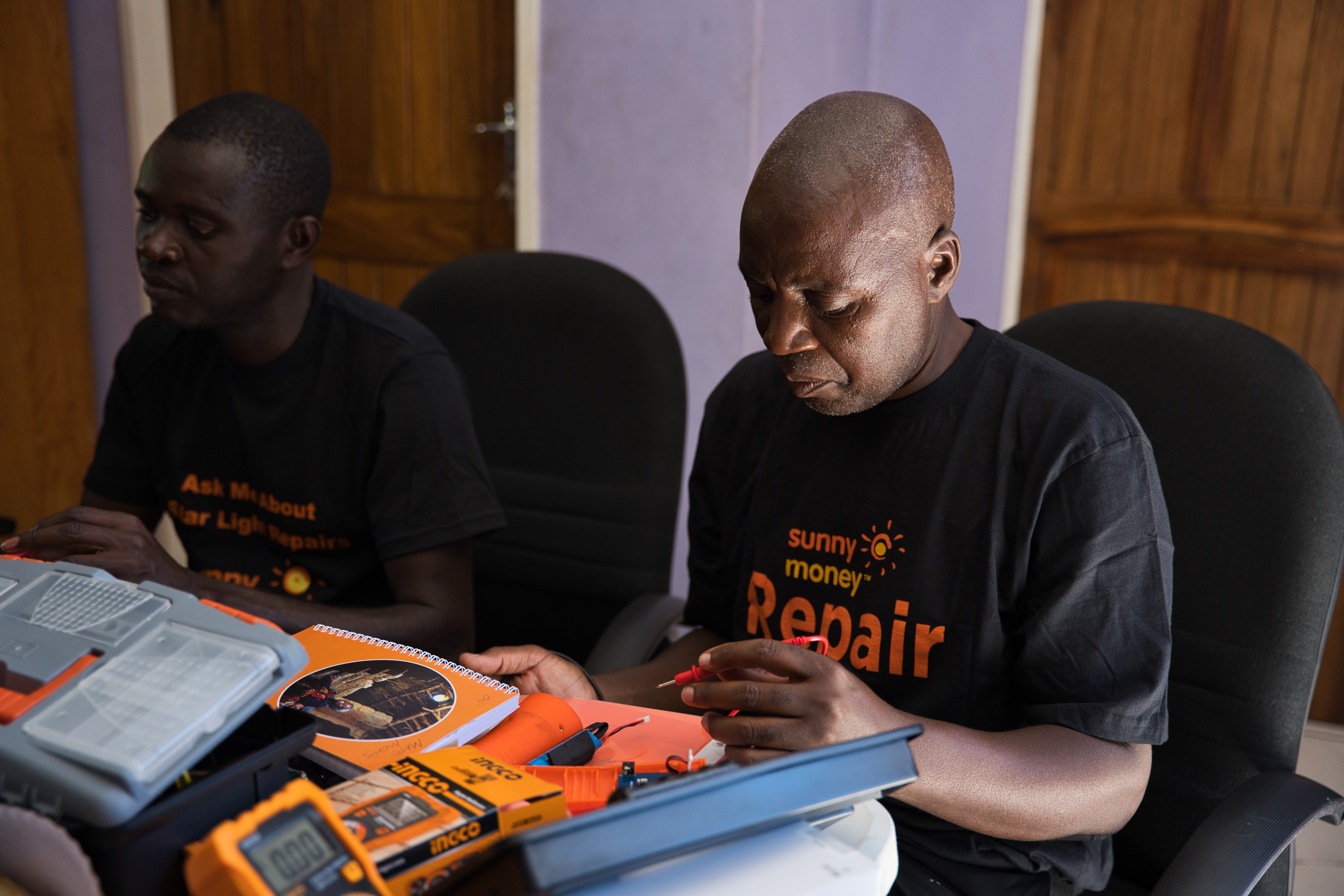 Moses Mate repairs a solar light